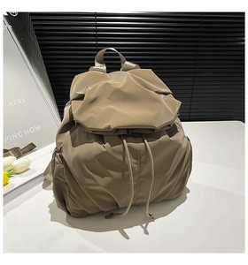 Detail of khaki drawstring backpack with pleated texture and side pockets for casual use