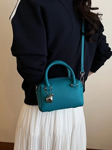 Mini sac à main Boston bleu sarcelle en cuir grainé avec breloque argentée sur mannequin