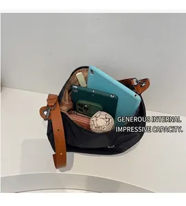 Détail de l'intérieur d'un grand sac cabas noir montrant l'espace pour tablettes et objets
