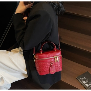 Close-up of red box handbag with woven leather texture and elegant fashion tag