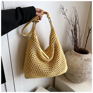 Close-up of yellow crochet beach bag showing large mesh weave and leather strap detail