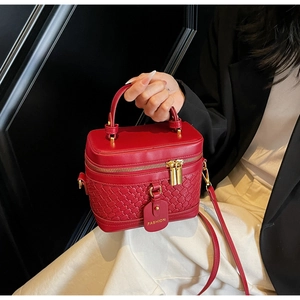Detail of red PU bucket bag showing woven texture, metal zippers, and fashion tag