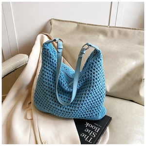 Detailed shot of sky blue woven shoulder bag with leather strap and silver ring buckle