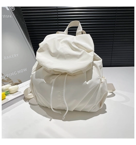 Detailed view of ivory drawstring backpack with premium pleated nylon texture and straps