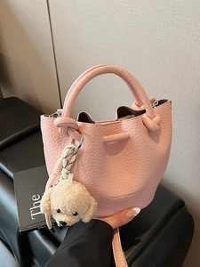 Pink litchi grain bucket bag with handles, shoulder strap, and cute plush dog charm