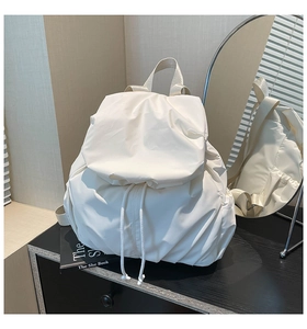 Detail of white nylon backpack with drawstring closure and soft pleated texture