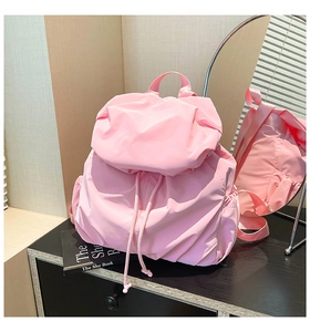 Detailed view of a pink nylon drawstring backpack with flap and side pockets