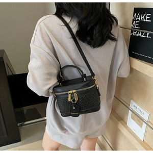 Detail of black woven PU leather box bag with gold double zippers and fashion charm
