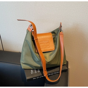 Gros plan sur le sac fourre-tout en nylon vert armée avec rabat en cuir et logo gaufré