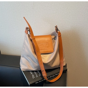 Détail du sac cabas minimaliste en nylon crème avec finitions en cuir contrastées