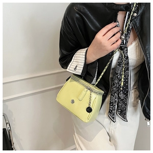 Détail du sac bandoulière en cuir jaune pâle avec fermoir camélia en métal et bandoulière