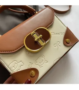Detail of vintage crossbody bag showing brown leather stitching and bear embossed pattern