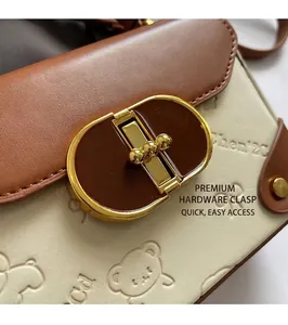 Macro detail of high-quality metal twist lock and embossed bear pattern on contrast bag