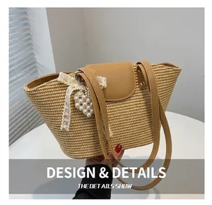 Close-up of straw tote bag with lace bow and pearl heart charm on leather handle