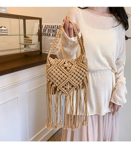 Detail of bohemian khaki woven cotton crossbody bag with long decorative fringe