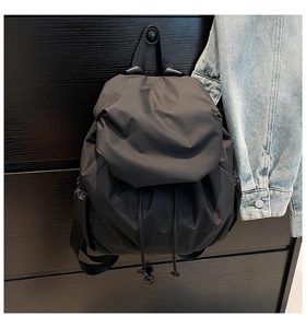 Detail of water-resistant black nylon backpack with drawstring closure and flap cover