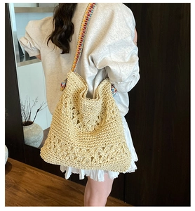 Détail d'un sac cabas en paille tissé avec une bandoulière géométrique colorée