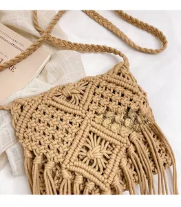 Detail of bohemian beige hand-woven crossbody bag with long tassels and intricate texture
