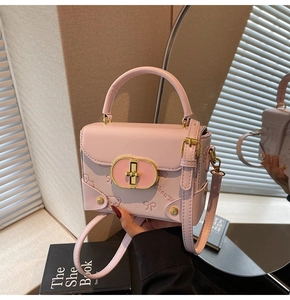 Detail of pink PU leather handbag featuring cute bear embossing and gold metal lock
