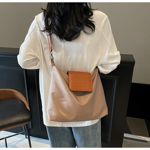 Détail du sac fourre-tout beige avec rabat en cuir marron et texte MAKE UP KITTEN embossé