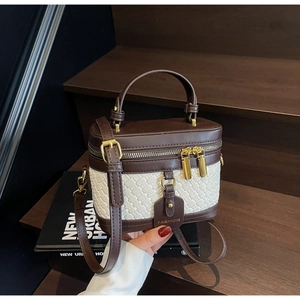 Detail of vintage box bag showing brown leather, woven texture, and gold hardware