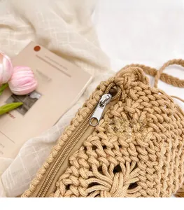 Close-up of fine woven texture and silver zipper on a beige handmade crossbody beach bag