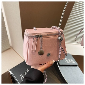 Détail du mini sac rose avec ornement de camélia en métal et bandoulière en chaîne