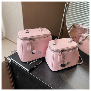 Vue détaillée du sac vanity rose en cuir grainé avec poignée chaîne et logo camélia