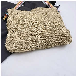 Détail du sac cabas en paille beige tissée avec bandoulière brodée au style ethnique