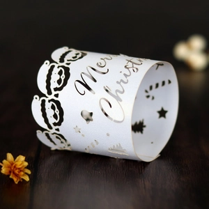 Detail of laser-cut white paper Christmas napkin ring with Merry Christmas lettering