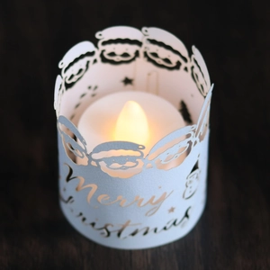 Christmas LED candle paper shade with cutout Santa and snowflake patterns on wood