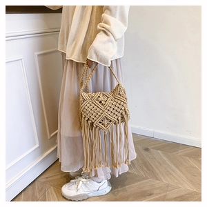 Detail of bohemian macrame woven bag with intricate diamond patterns and long fringe accents