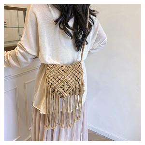 Detail of bohemian beige hand-woven crossbody bag with fringe tassels and crochet texture