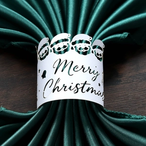 Macro d'un rond de serviette Merry Christmas blanc avec Père Noël sur tissu vert