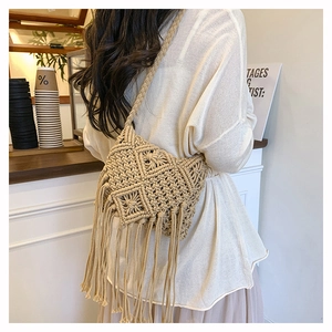 Detail of bohemian macrame woven bag with intricate geometric patterns and long fringes