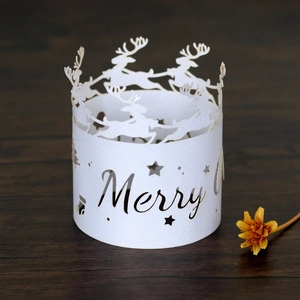 Detail of white laser-cut Christmas reindeer paper lampshade on wood surface
