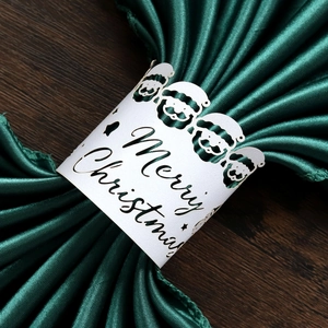 Détail du rond de serviette Père Noël en papier découpé sur satin vert foncé