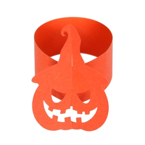 Detail view of orange paper pumpkin napkin ring with cutout Jack-o'-lantern face for Halloween