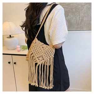 Detailed view of handmade woven cotton crossbody bag with long bohemian tassels and texture