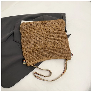 Détail du sac en paille tissé à la main avec motifs floraux et bandoulière en jacquard