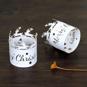 Detail of white laser-cut napkin ring with Merry Christmas text and reindeer motifs