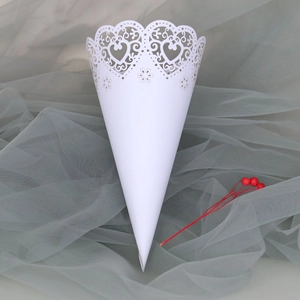 Detail of laser-cut white paper confetti cone with elegant heart and floral lace edges
