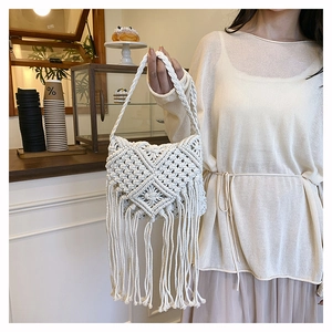 Detail of handmade macramé crossbody bag with geometric weave and long fringe tassels