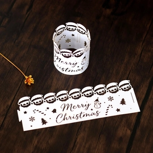 Detailed laser-cut white Christmas paper candle shade with Santa and snowflake patterns