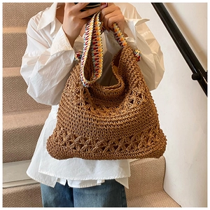 Détail du sac cabas en paille tissé avec motifs ajourés et bandoulière multicolore