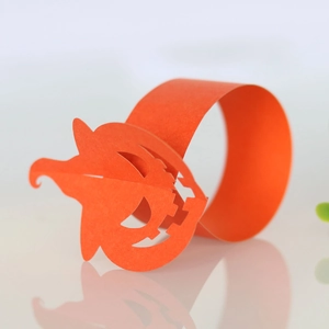 Detailed view of an orange paper pumpkin napkin ring for Halloween table decor