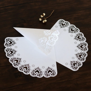 Macro detail of laser-cut heart lace pattern on white wedding confetti cones