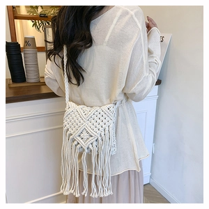 Detail of handmade macramé crossbody bag featuring geometric patterns and long fringes