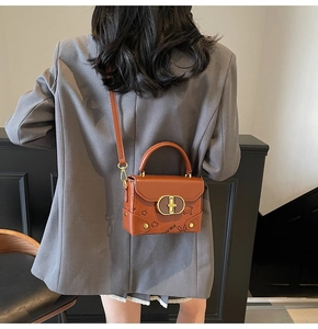 Detail view of brown leather bag with golden buckle and cute cartoon pattern printing