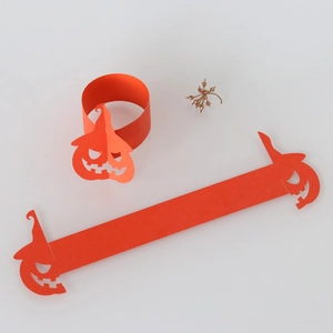 Macro view of orange pumpkin paper napkin rings with cutout festive face designs